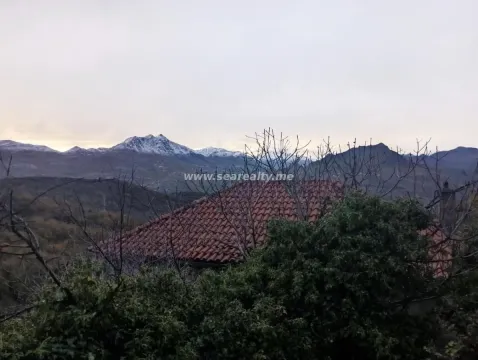 Pogled na planinske vrhove sa dijelom krova i prirode u prvom planu. - image 2