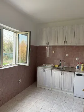 A simple kitchen with light-colored cabinets and an open window. - image 13