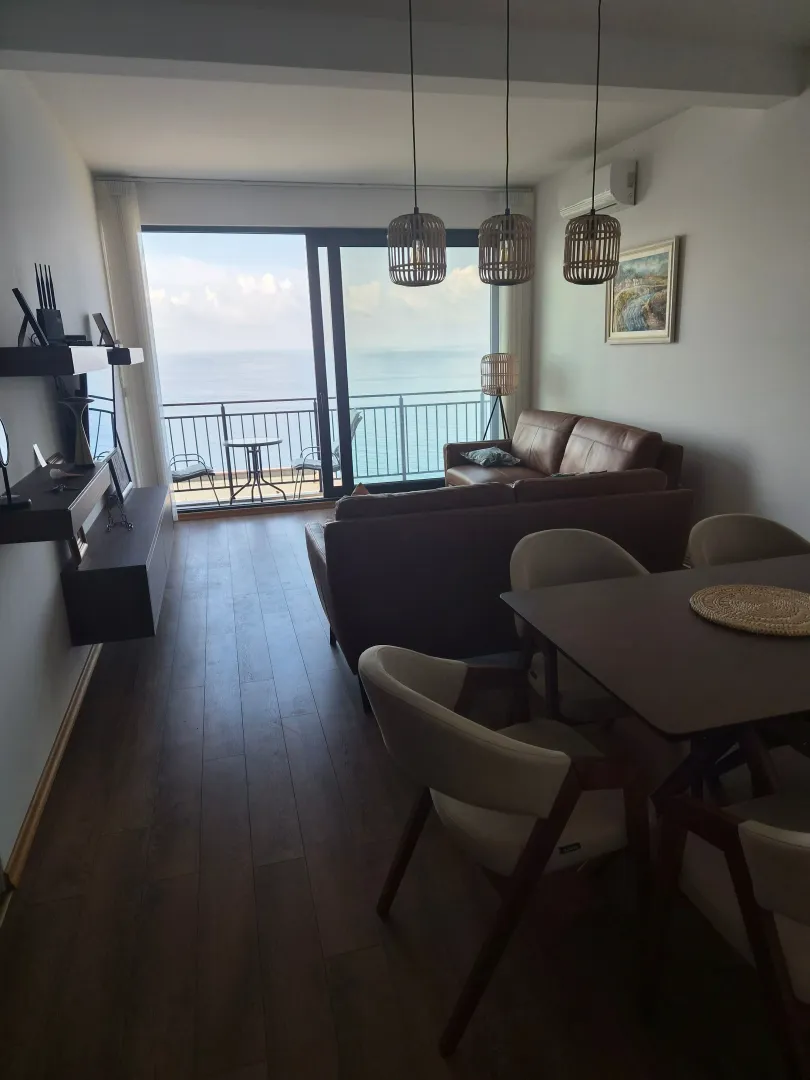 Spacious living room with a dining area and a sea view.