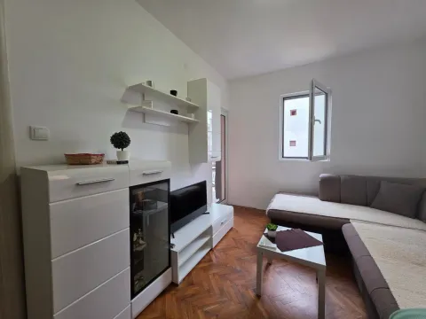 Living room with a sectional sofa, TV, and white furniture unit. - image 21