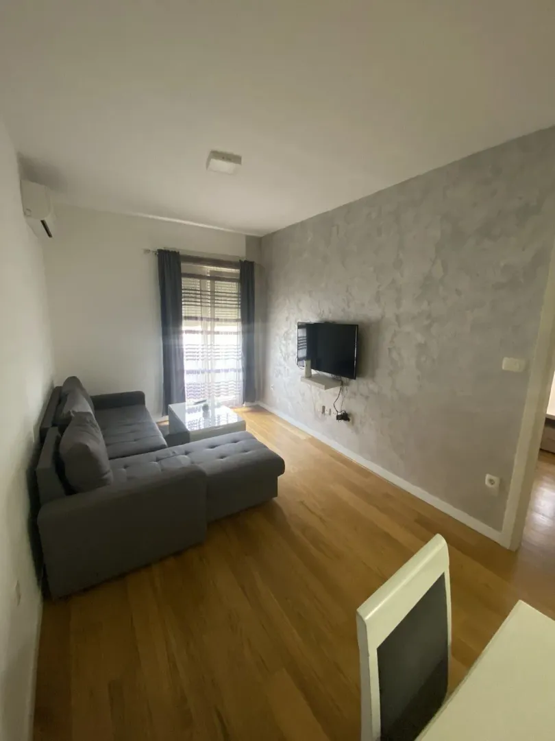 Living room with a grey sectional sofa and a wall-mounted TV.