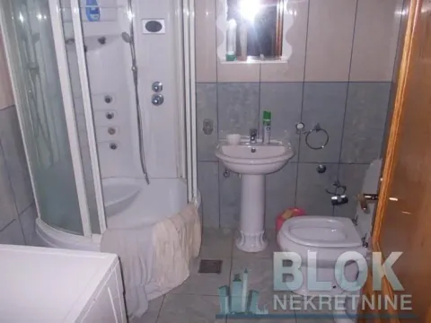 Bathroom equipped with a shower cabin, washbasin, and toilet. - image 5