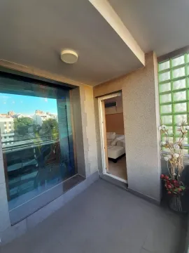 Covered balcony with a city view and access to the interior. - image 6
