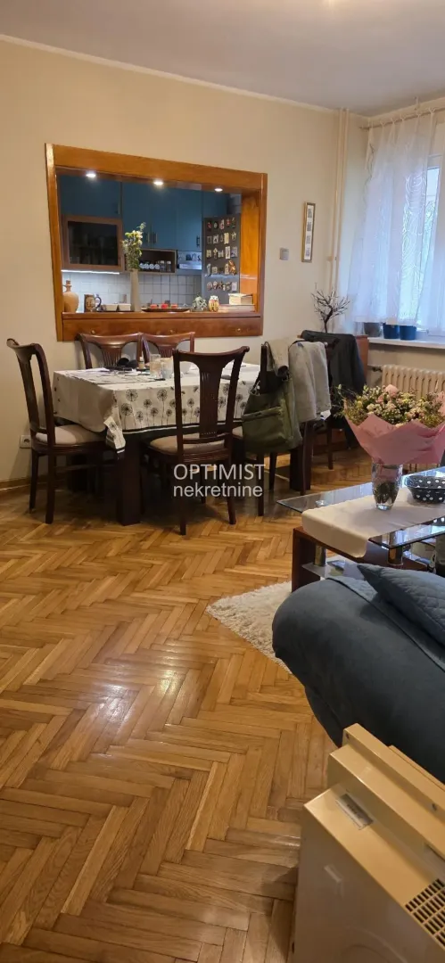 Living room with a dining area and a pass-through window looking into the kitchen.