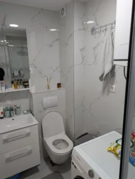 Manje kupatilo sa bijelim pločicama sa teksturom mermera, umivaonikom, wc šoljom i veš mašinom. - image 8
