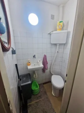 Manje kupatilo sa belim pločicama, toaletom i umivaonikom. - image 16