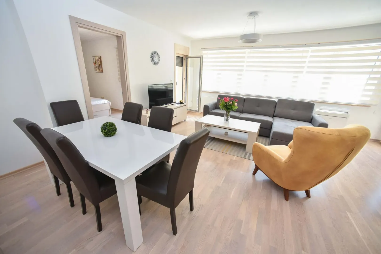 Living room with dining area, sofa and table.