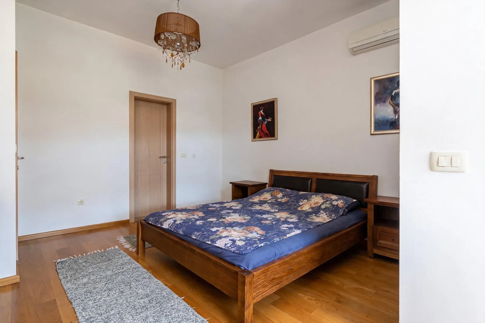 Svijetla spavaća soba sa drvenim krevetom.