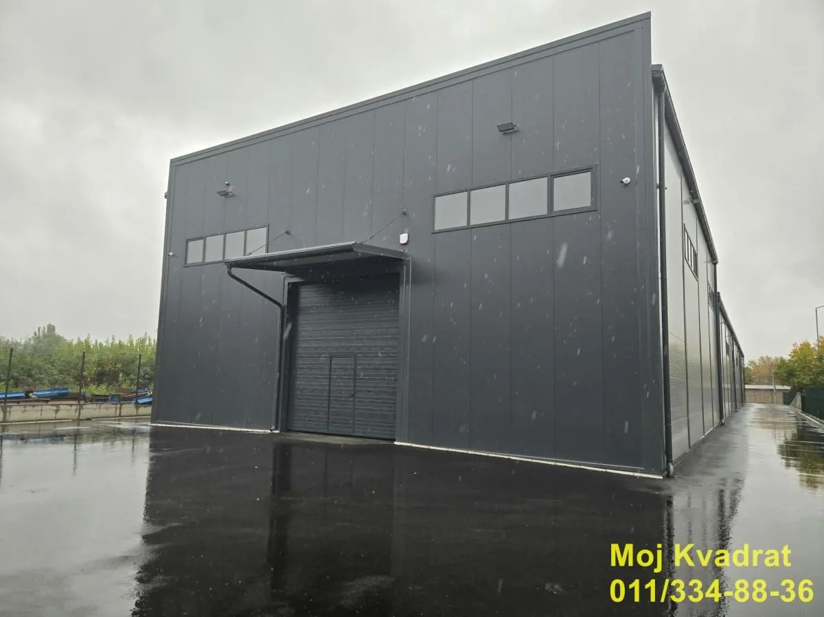Exterior view of a modern industrial hall with a dark metal facade.
