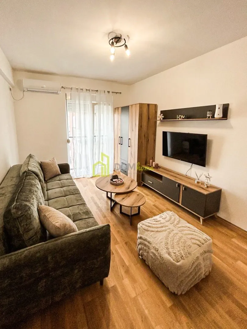 Living room with sofa, TV and access to the terrace.