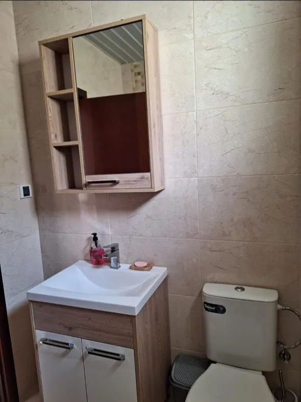 Small bathroom with a sink, mirrored cabinet, and toilet.