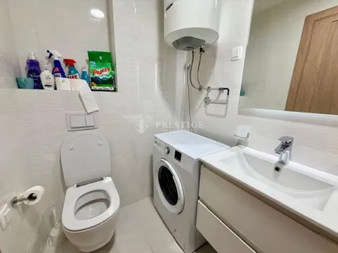 Compactly equipped bathroom with sanitary fixtures, a sink, and a washing machine. - image 10