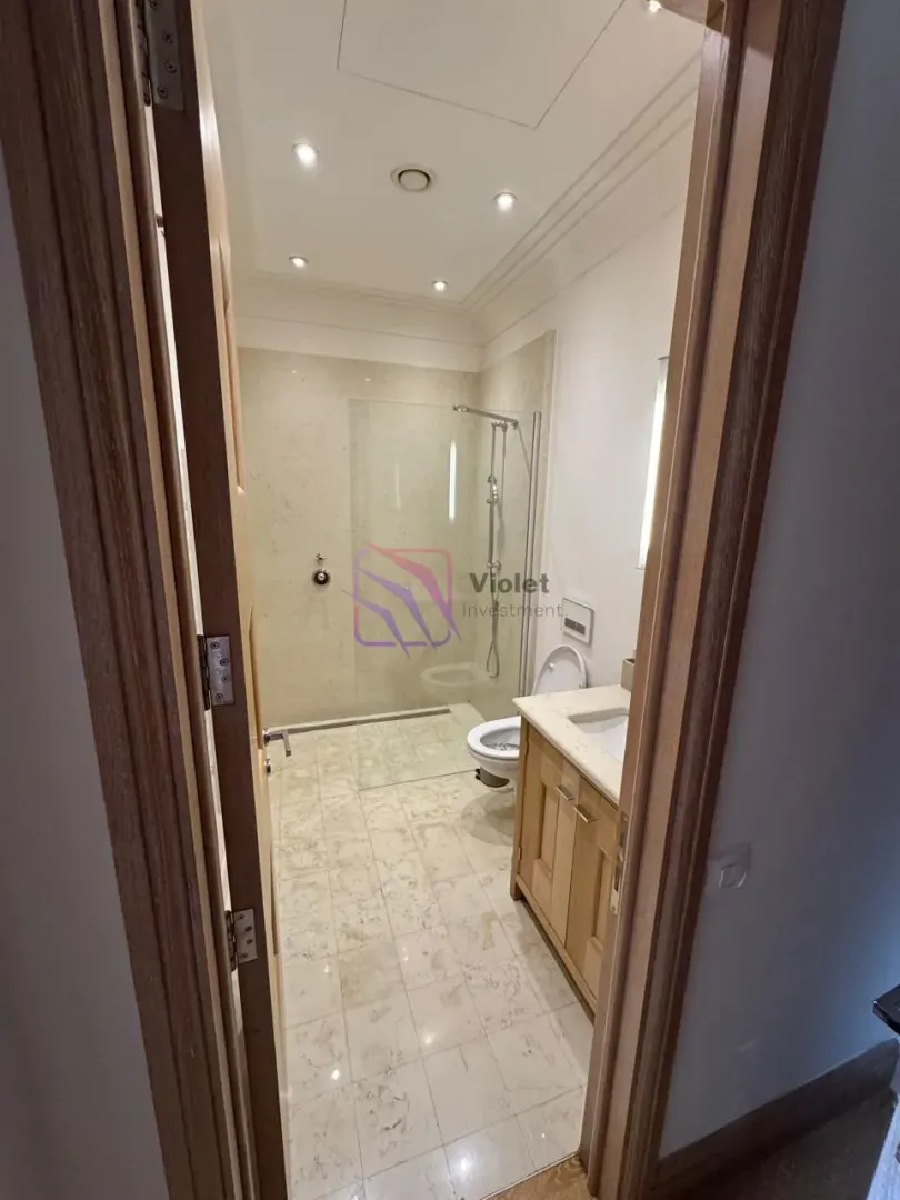 View from the hallway into a modern bathroom with a walk-in shower.