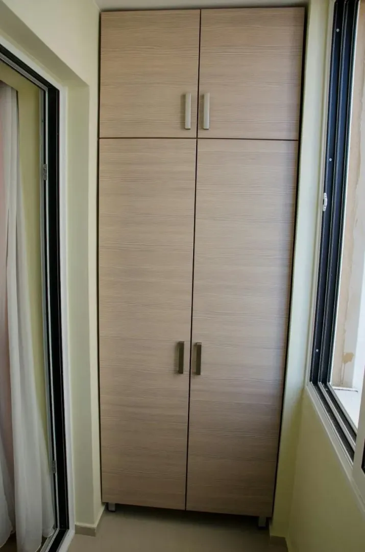 Built-in wooden wardrobe on a closed balcony.