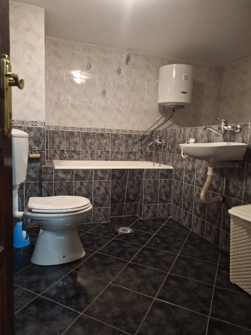 Bathroom equipped with sanitary fixtures, a bathtub, and a water heater.