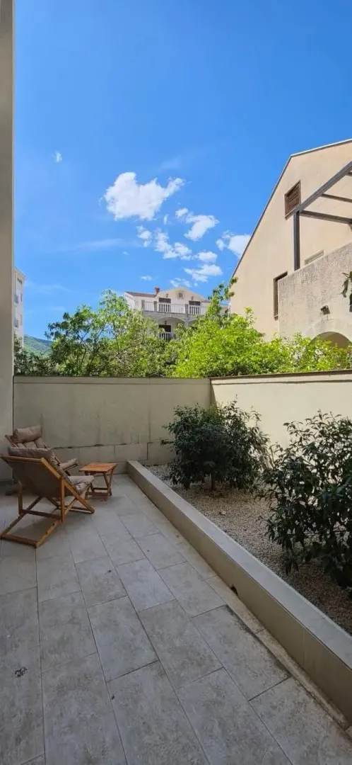 Tiled courtyard with sun loungers and decorative plants.