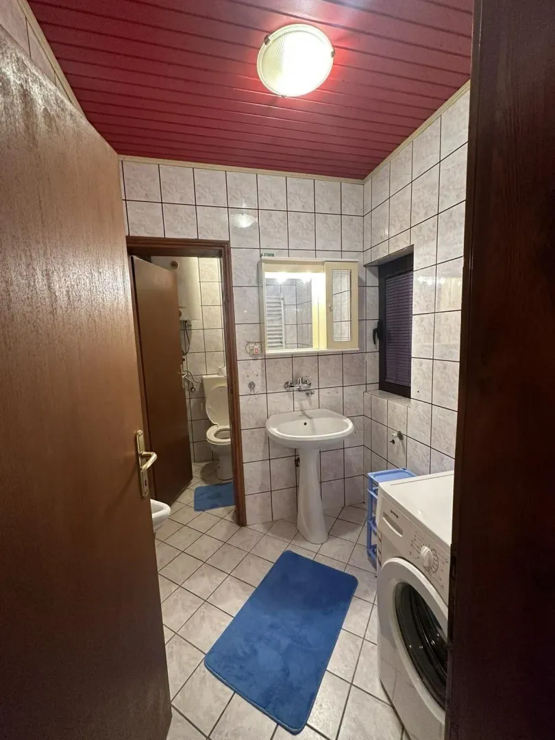 Praktično kupatilo sa veš mašinom i lavaboom.