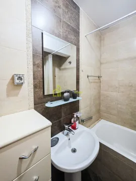 Kupatilo opremljeno umivaonikom, ogledalom i kadom sa tuš zavjesom. - image 6