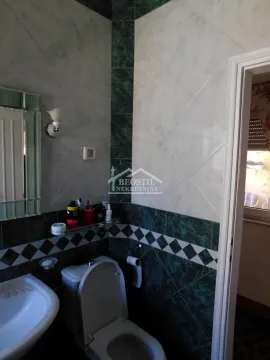 Manje kupatilo sa keramičkim pločicama, umivaonikom i wc šoljom. - image 5