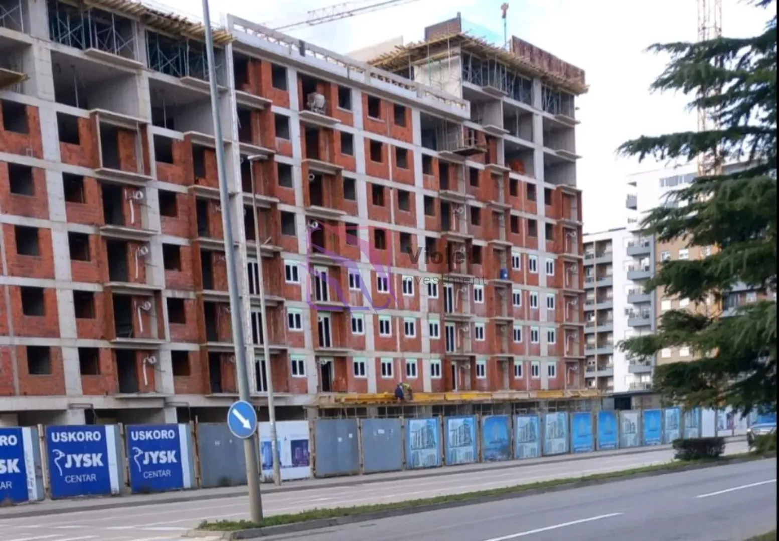 Stambena zgrada u izgradnji pored puta.