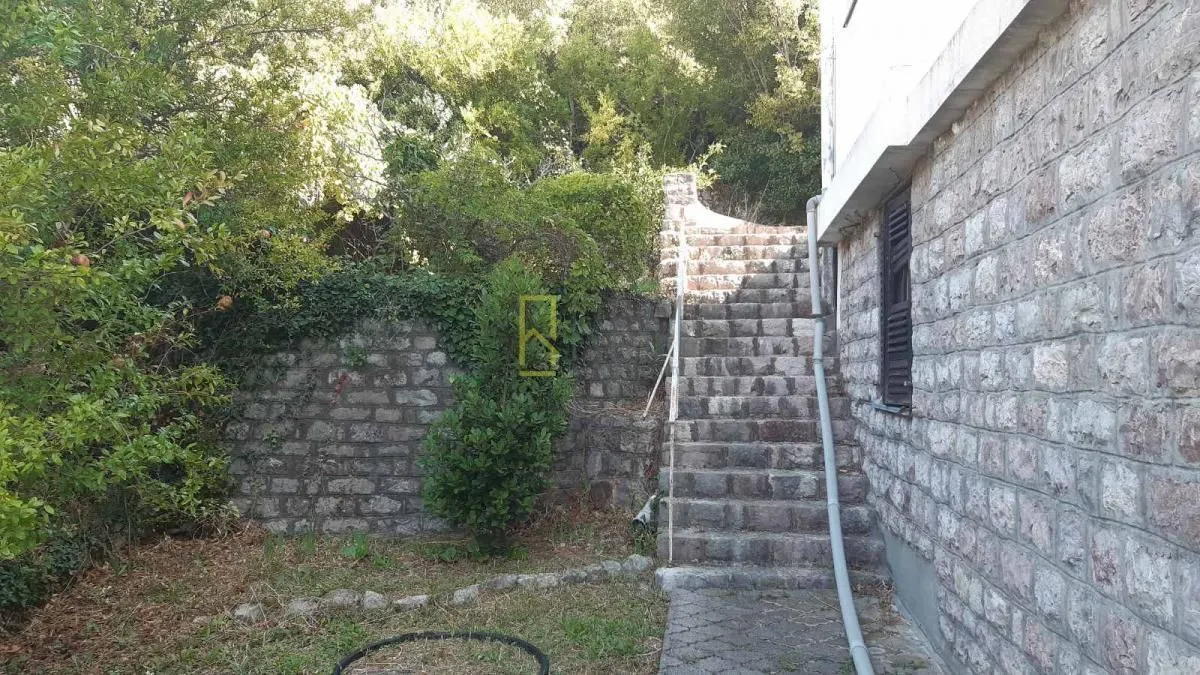 Kamene stepenice koje vode do ulaza u kuću sa dvorištem.