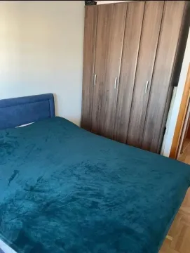 Spavaća soba sa bračnim krevetom i drvenim ormarom. - image 3