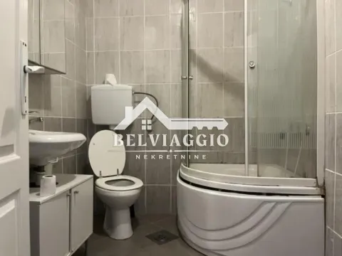 Bathroom equipped with a shower cabin, washbasin, and toilet. - image 8