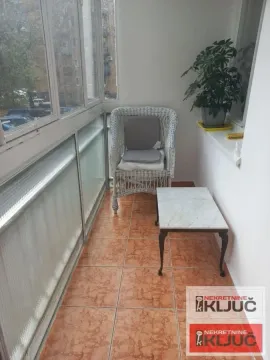 Zastakljeni balkon sa stolićem i pletenom foteljom. - image 4