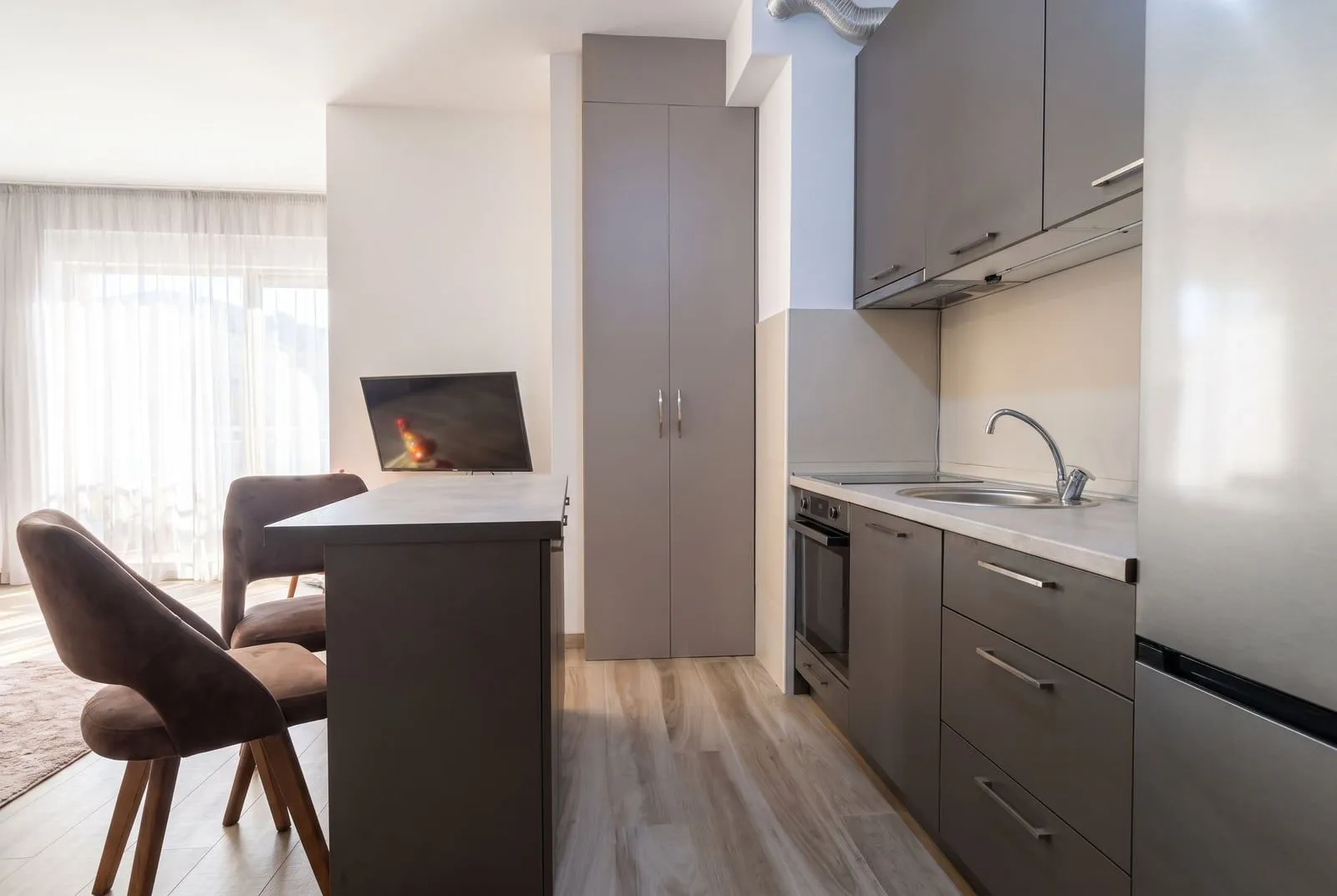 Modern kitchen with dark cabinets and a dining island.