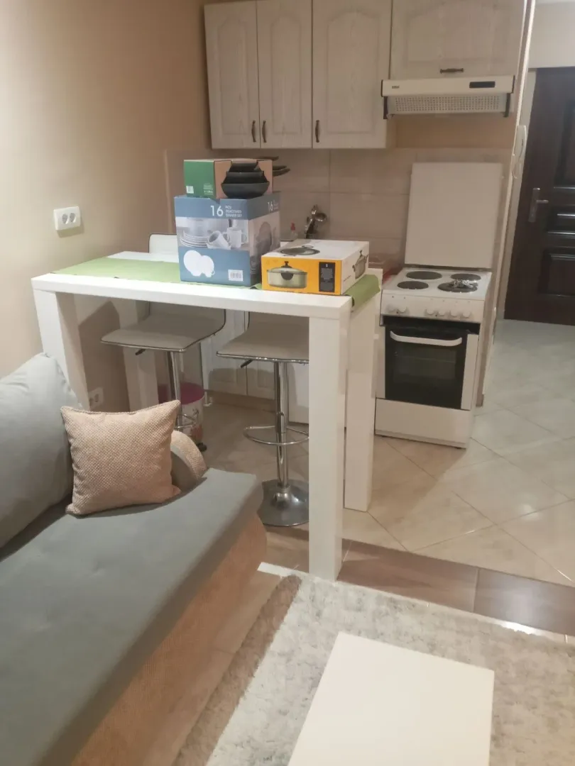 Kuhinja sa šankom, stolom i pogledom na dio dnevnog boravka.
