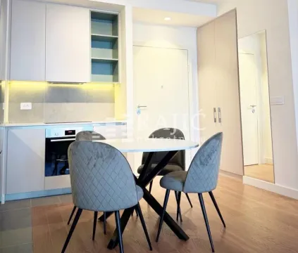 Modern kitchen with dining area and built-in appliances. - image 7