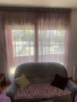 A sofa in front of a window with curtains. - image 6