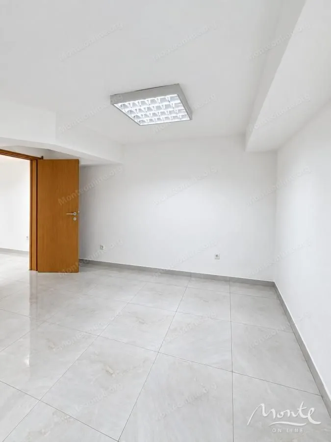 Empty room with light floor tiles and white walls.