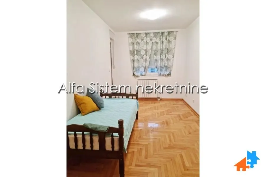 Small bedroom with a bed and parquet flooring.