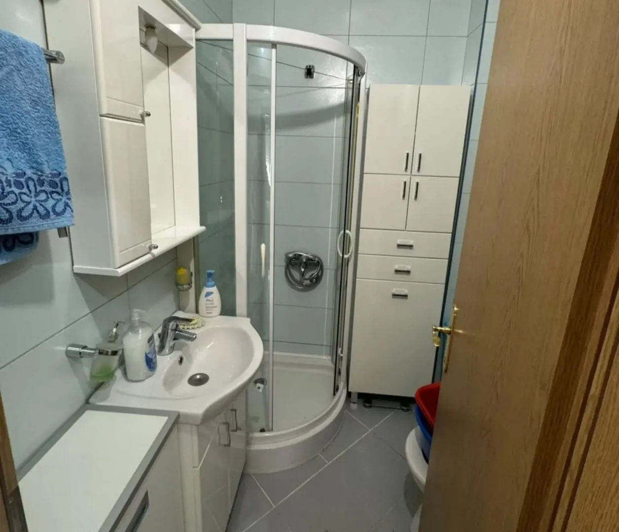 Bright bathroom with a shower cabin and sink.