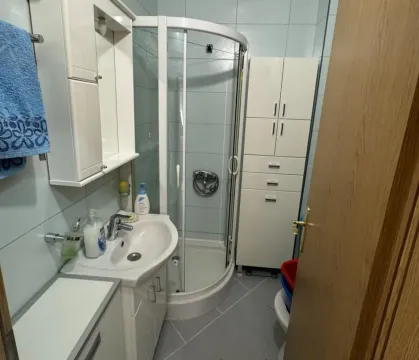 Bright bathroom with a shower cabin and sink. - image 6