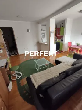 Living room with a sofa, coffee table, and a view of the dining area and kitchen. - image 17