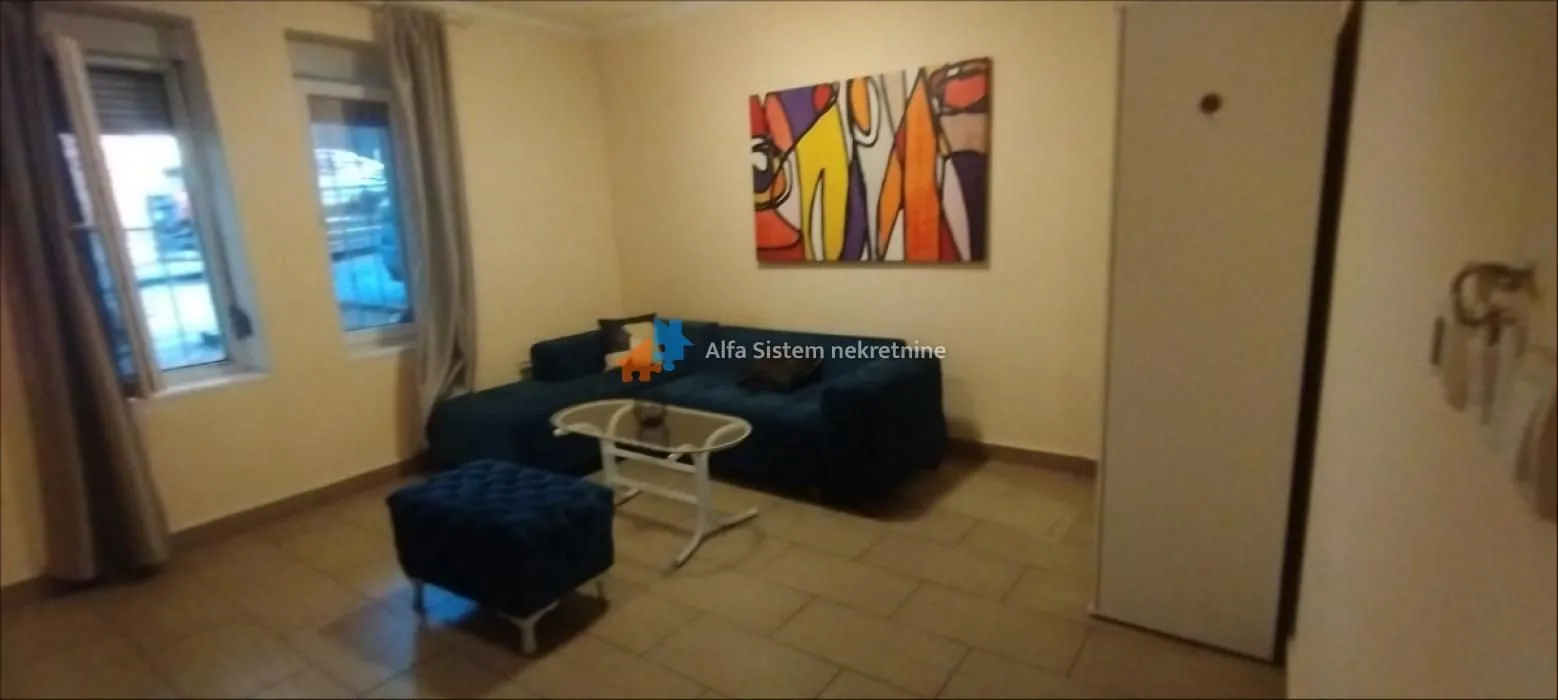 Living room with a blue sofa, coffee table, and a painting on the wall.
