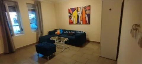 Living room with a blue sofa, coffee table, and a painting on the wall. - image 3