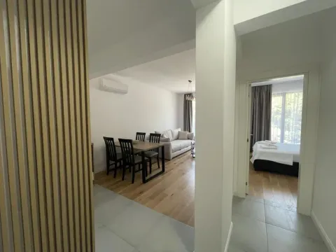 View from the hallway towards the living room with a dining area and a bedroom. - image 3