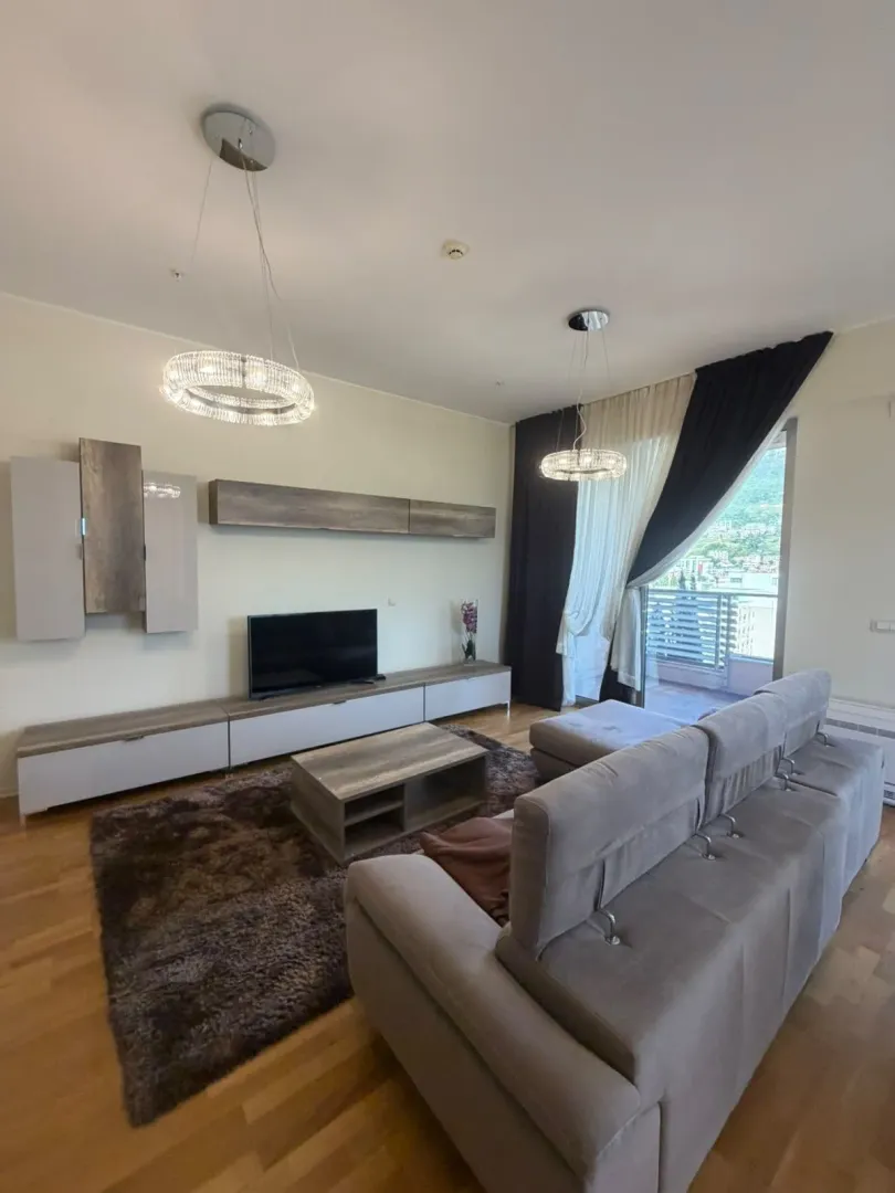 Living room with sofa, TV unit, and terrace access.
