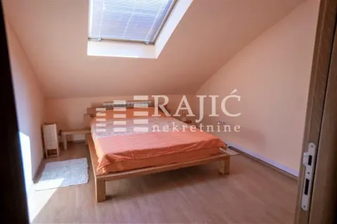 Attic bedroom with a double bed and a skylight. - image 2