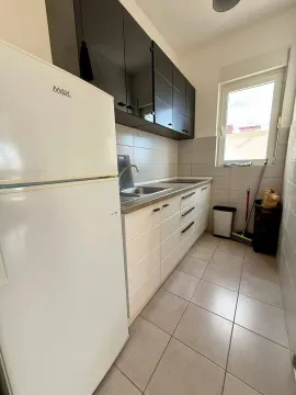 Smaller kitchen with white cabinets, refrigerator, and sink. - image 5