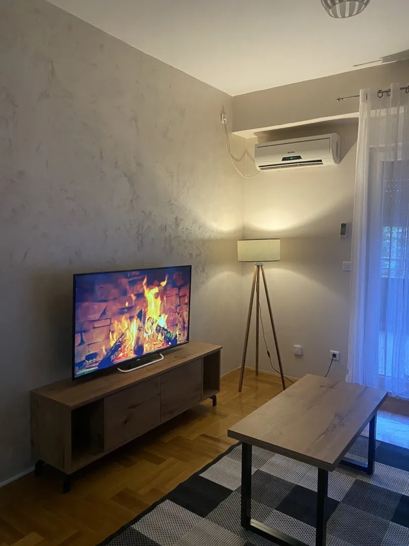 Living room with a TV, coffee table, and floor lamp.