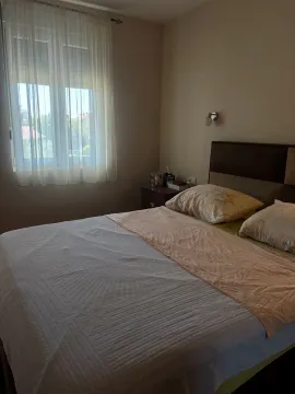 Namještena spavaća soba sa bračnim krevetom i prozorom. - image 4