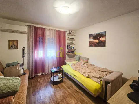 Dnevni boravak sa krevetom i prozorom prekrivenim zavjesama. - image 5