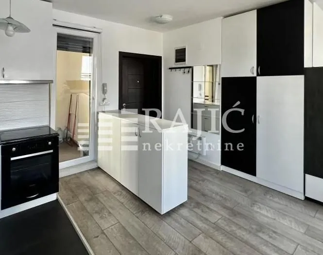 Modern kitchen with built-in units and dining area.
