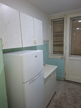 Kitchen with white cabinets, a refrigerator, and a door leading to the terrace. - image 11