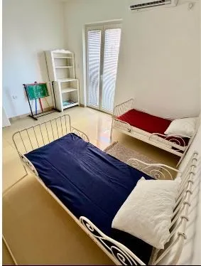 Children's bedroom with two single beds and balcony access.