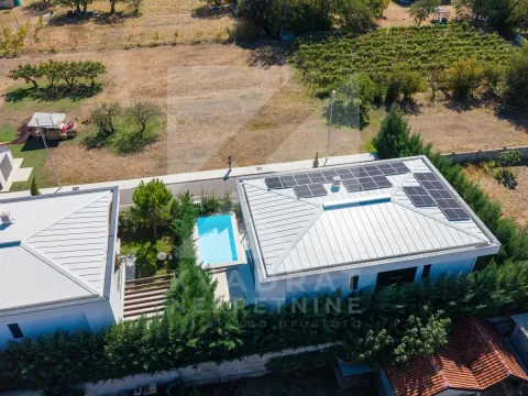Aerial view of a house with a swimming pool and solar panels on the roof. - image 27